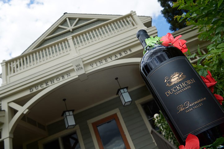 Discussion bottle with rose wreath in front of estate house